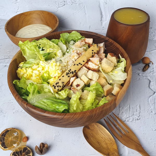 Making Chicken Caesar Salad in a Wooden Bowl